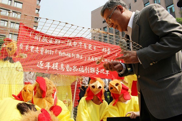 農委會畜牧處副處長朱慶誠親自打開囚禁蛋雞的格子籠，象徵政府將給予協助並重視此事。 何宜/攝